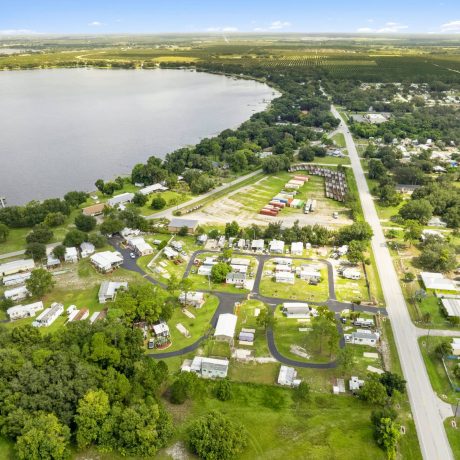 A wide-angle view of Lake Letta RV Park in Avon Park, FL, showcasing the homes and beautifully landscaped surroundings in the 55+ community.