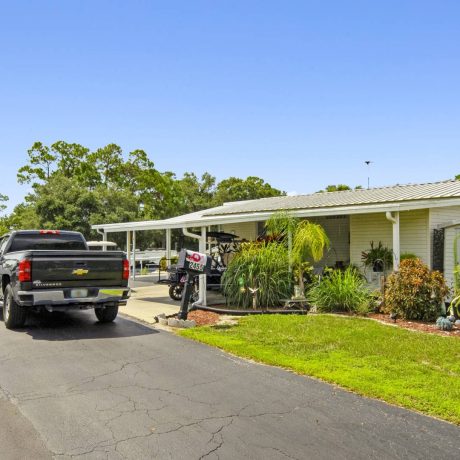 The exterior of a tropical-style clubhouse where seniors can enjoy activities and events at Lake Letta RV Park in Avon Park, FL.