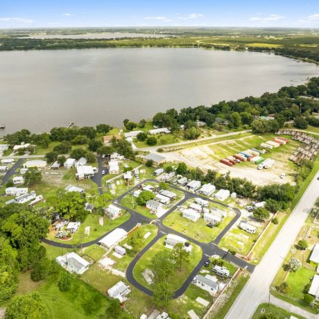 A wide-angle view of Lake Letta RV Park in Avon Park, FL, showcasing the homes and beautifully landscaped surroundings in the 55+ community.