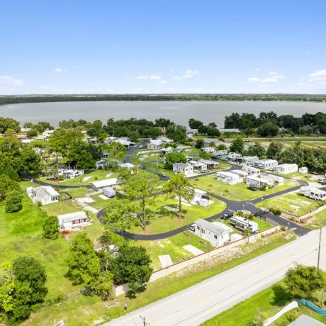 A wide-angle view of Lake Letta RV Park, showcasing the homes and beautifully landscaped surroundings in the 55+ community of Avon Park, FL.