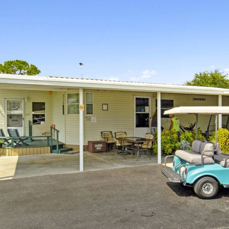 The exterior of a tropical-style clubhouse where seniors can enjoy activities and events at Lake Letta RV Park in Avon Park, FL.