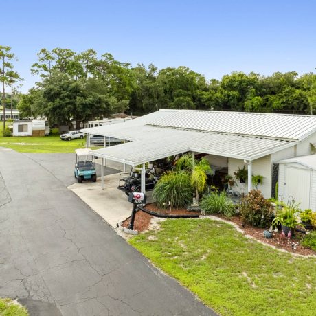 The exterior of a tropical-style clubhouse where seniors can enjoy activities and events at Lake Letta RV Park in Avon Park, FL.