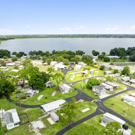 A wide-angle view of Lake Letta RV Park, showcasing the homes and beautifully landscaped surroundings in the 55+ community of Avon Park, FL.